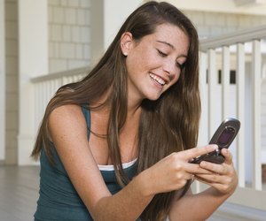Smiling teenage girl using cell phone