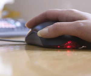 Hand touching computer mouse