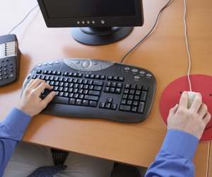 High angle view of a young man's hands working on a computer
