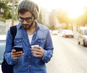 Modern young man with mobile phone in the street.