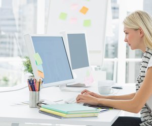 Casual young woman using computer in office
