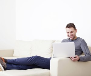Man sitting on sofa with digital tablet