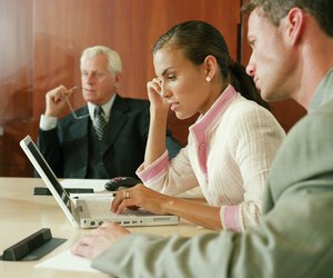 Businesswoman using laptop in boardroom meeting