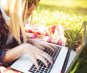 Attractive woman using laptop in the park