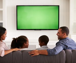 Parents and children watching TV, looking at each other
