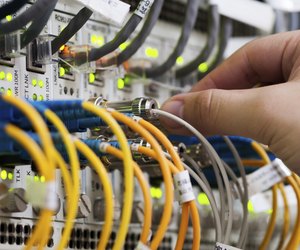 woman connecting network cables to switches