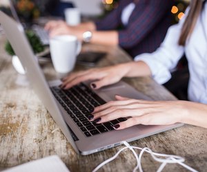 Young woman using laptop at home office. Modern office interior,