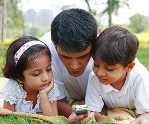 Father showing his mobile to his children