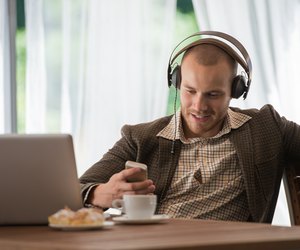 Young man listening to music with headphones at a cafe