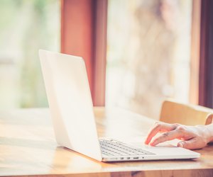 Hand woman typing key pad of laptop.