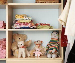 Stuffed animals, clothing and towels on shelves in closet