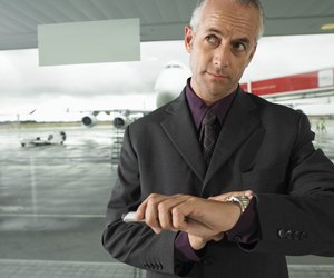 Mature businessman checking time in airport