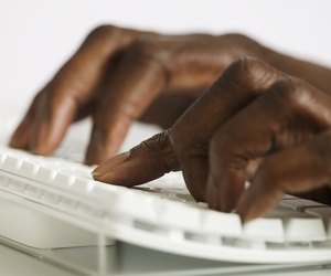 Close-up of a man's hands working on a computer keyboard