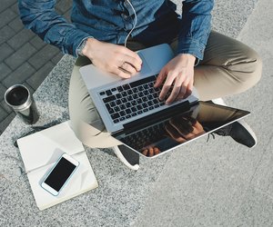 Smartphone, coffee tablet and laptop in man hands outdoors