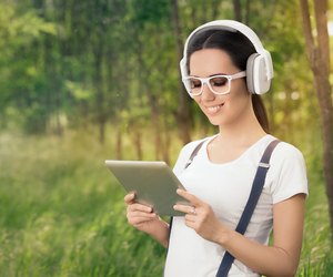 Girl with Headphones and a Tablet PC