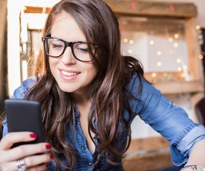 Young beautiful hipster woman using smart phone at office