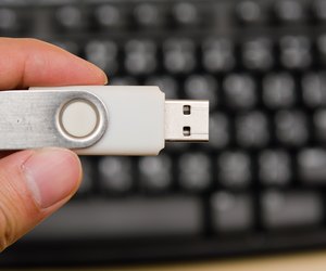 USB thumb drive with hand holding on keyboard background