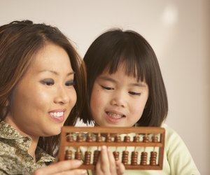 Mother and daughter using an abacus together