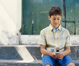 Boy (6-9) using mobile phone