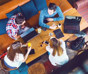 Group of young people sitting at a cafe, top view