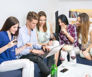 Group of cheerful young people looking at the laptop together.