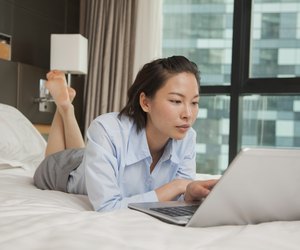 Businesswoman working on her laptop in the bed