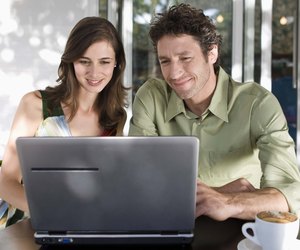 Couple using laptop computer in coffee shop