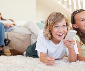 Siblings lying on the floor watching tv