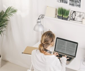 Back view of mature businesswoman working with laptop at home.