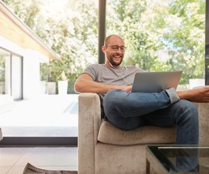 Happy mature man having video call on laptop