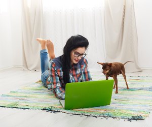 Young girl on white sofa with a laptop