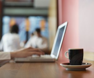 Young businesswoman with laptop and cup of coffee