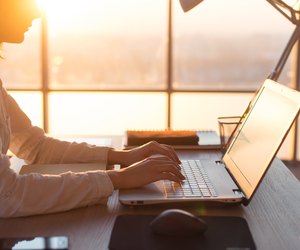 Female teleworker texting using laptop and internet, working online. Freelancer