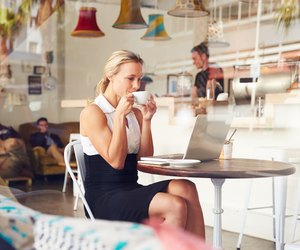 Business woman sitting at a table in small coffee shop
