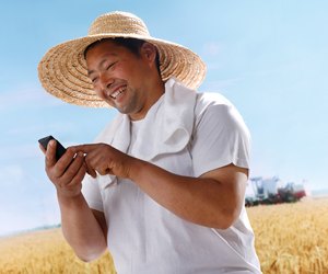Farmer making phone call in wheat field