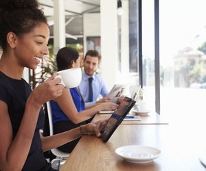 Businesswoman Using Digital Tablet In Coffee Shop