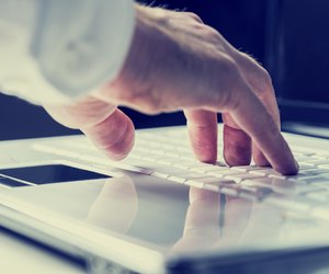 Man typing on a laptop keyboard