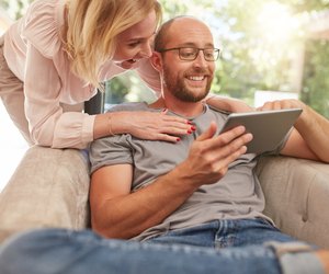 Couple using a digital tablet smiling
