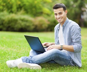 Student using laptop on the grass