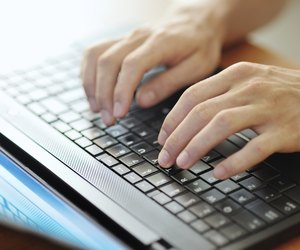 male hands typing on a laptop pc keyboard