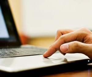 Student's finger on trackpad of computer.