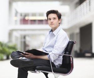 Teenage boy sitting in office chair, looking away