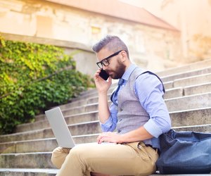 Hipster businessman with phone and laptop