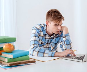 Cute young student using laptop