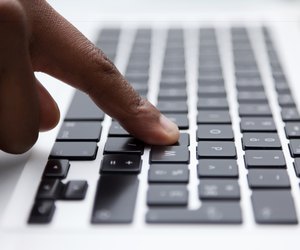 black finger typing on computer keyboard