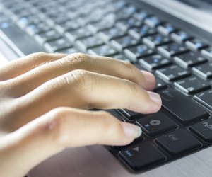 Hand typing on laptop keyboard.