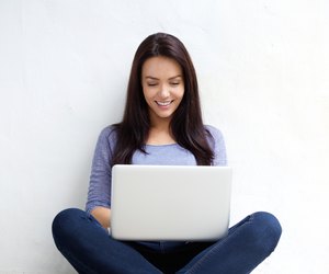 Smiling young woman using laptop