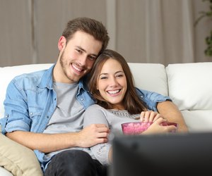 Happy couple watching movie on tv