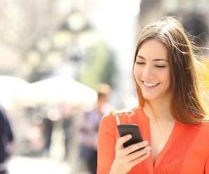 Woman wearing orange shirt texting on the smart phone