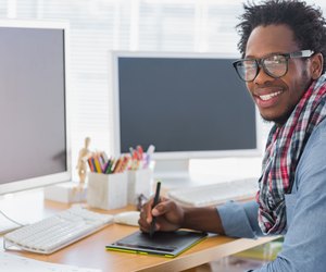 Smiling graphic designer using a graphics tablet